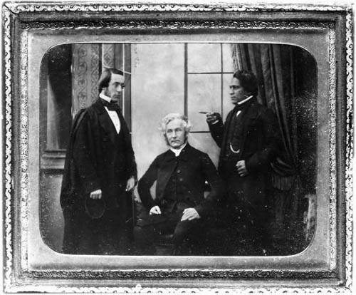 A photograph showing two Pakeha men and a Maori man