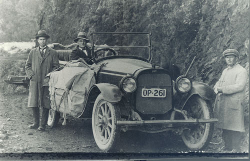 Jack Musgrave at the wheel of a service car in the Waimana Gorge, Bay of Plenty, probably after 1918