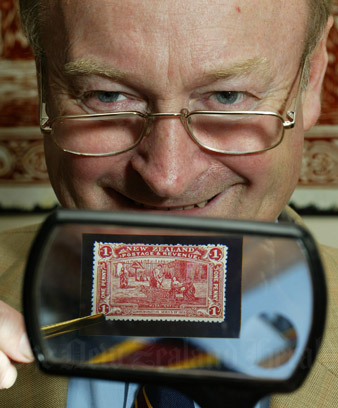 John Mowbray with a rare one-penny claret stamp. Source: New Zealand Herald
