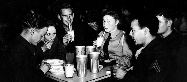 A group of people enjoy milkshakes or malted milk, soft drinks and ice cream sundaes