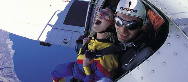 A skydiver prepares to leap from a plane