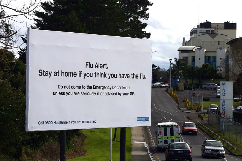 A billboard next to a hospital.