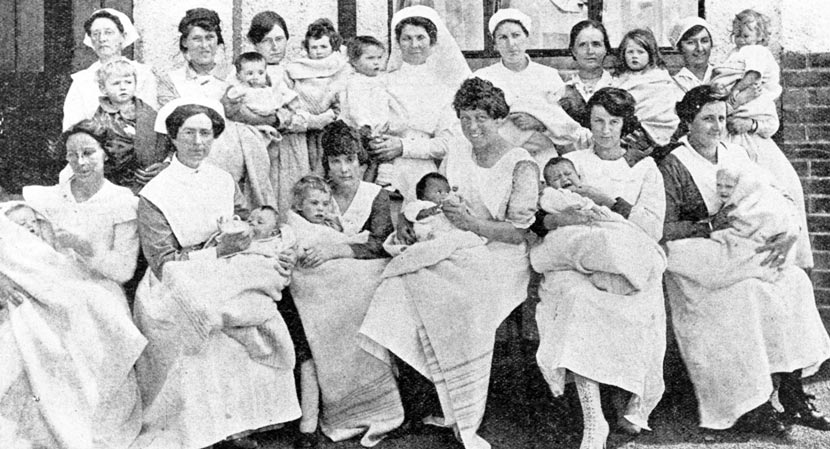 Numerous women holding young children and babies.