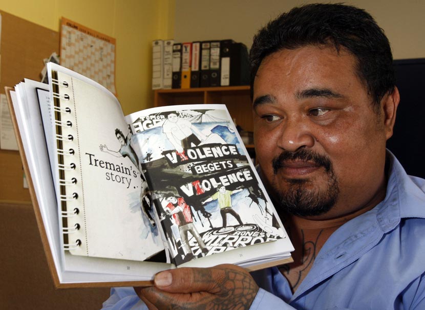 Māori man holding an open book.