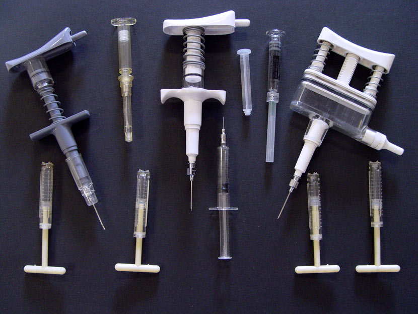 A photograph showing 11 plastic syringes of a variety of styles