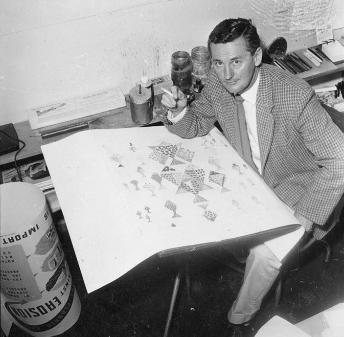Man seated with a wallpaper sample in front of him. 