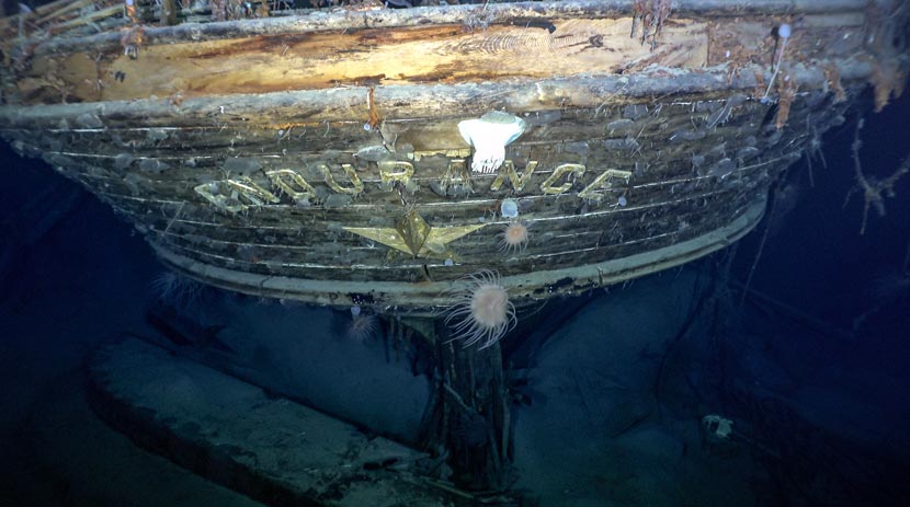 Underwater photograph of the rear of a sunken ship with the letters Endurance visible in gold lettering.