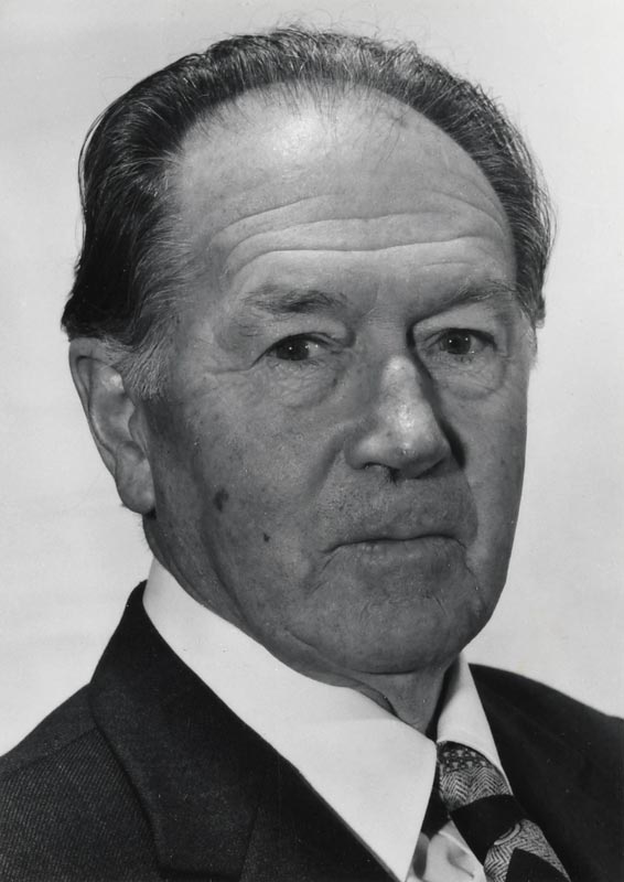 A formal head and shoulders portrait of Lindsay Poole as an older man, wearing a suit and tie. 