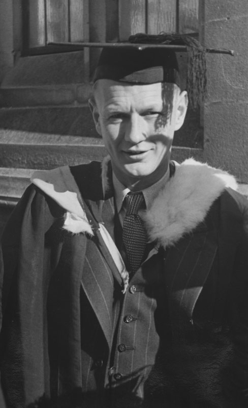 A photograph of Bill Pearson in a graduation gown and cap.