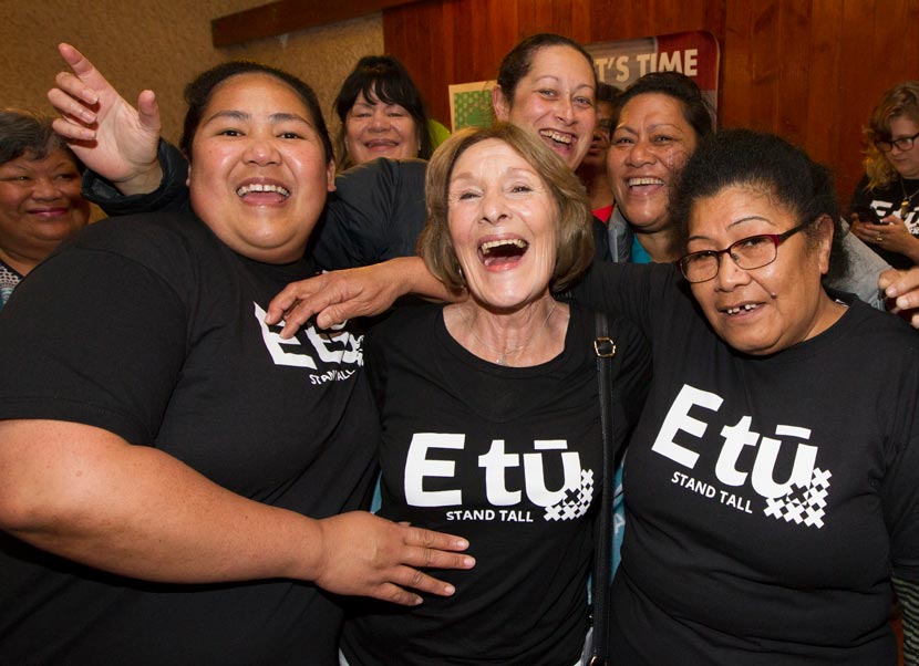 Group of women in black E tū t-shirts smiling and laughing.