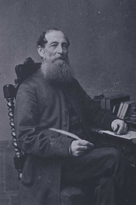 A photograph of Thomas Grace seated at a desk