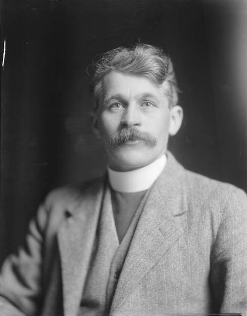 A head and shoulders photograph of John Laughton wearing a clerical collar