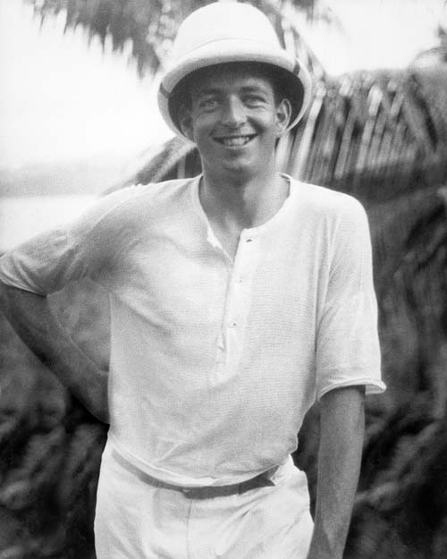 A photograph of Emmet McHardy wearing a pith helmet in an outdoor tropical setting