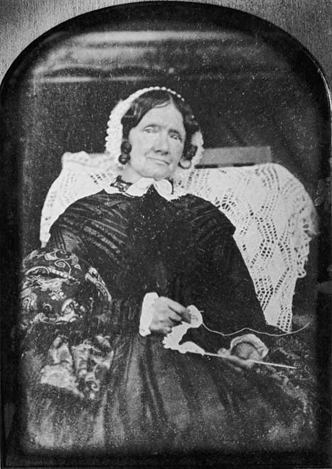 Marianne Williams, seated and wearing a bonnet, with crocheting in her hands.