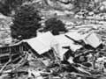 A devastated landscape with broken buildings and river debris.