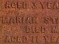 A gravestone in a cemetery listing the names of five children from the same family.