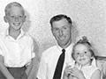 A black and white formal portrait showing Roly and Irene Earp and their family, well-groomed and tidily dressed. The adults, in their thirties, are seated in wicker chairs, each with a young child on their laps, with two older children standing between them. 