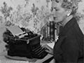At her typewriter
