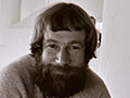 A photograph of a bearded Ian Athfield seated indoors