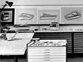 A photograph showing a room with a work desk, office furniture, sketches and models