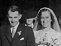 Owen Woodhouse and Peggy Thorpe, wearing wedding outfits, stand in a church doorway, surrounded by friends and family.