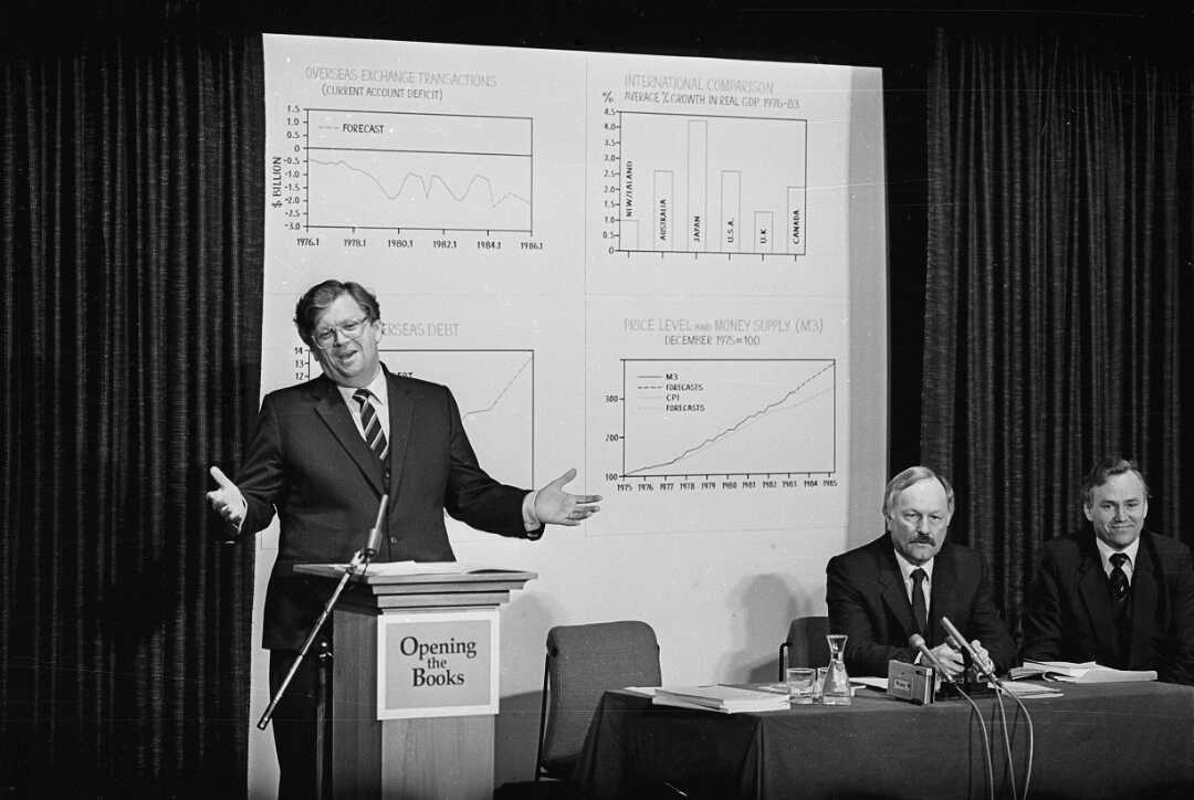 David Lange speaking in front of whiteboard with graphs