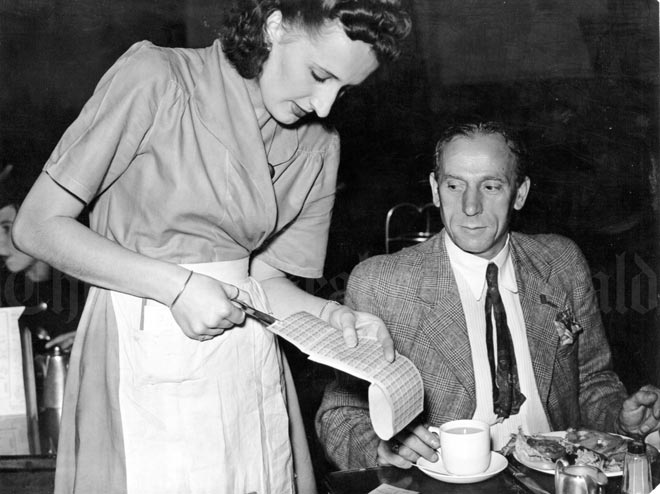 Waitress clipping the meat ration coupon, 1944