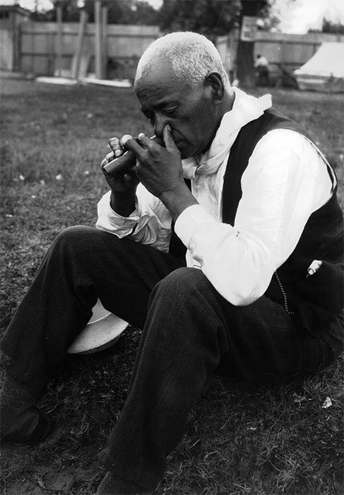 Playing the nose flute, 1923