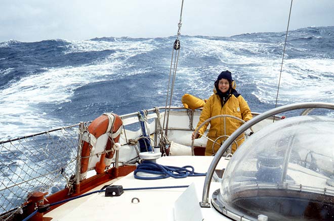 Woman steering boat in heavy seas