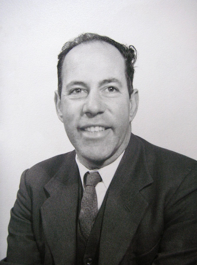 A head and shoulders portrait of a middle-aged man in a suit and tie.