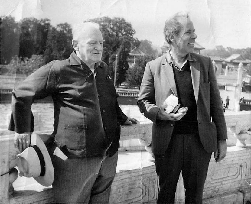 Two men standing side by side outdoors.