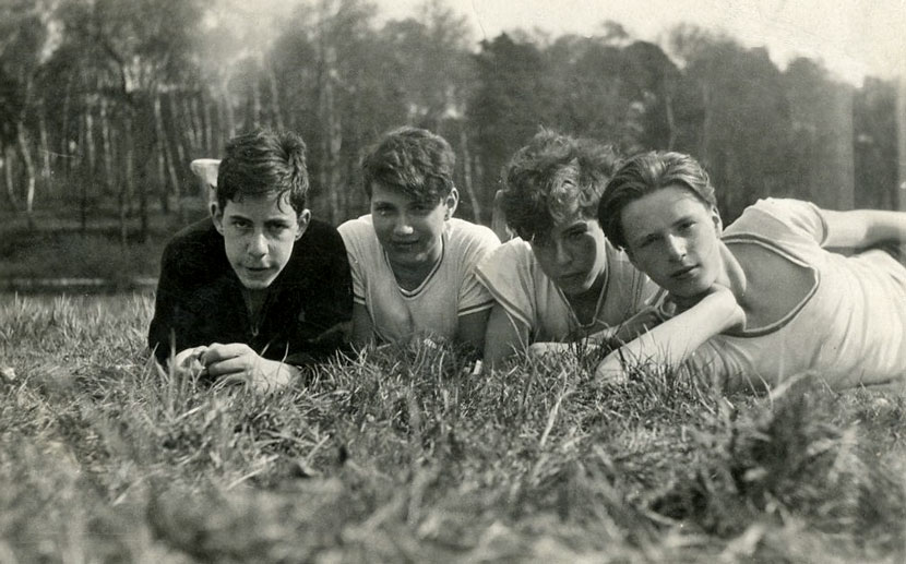 Four teenage boys lying on grass