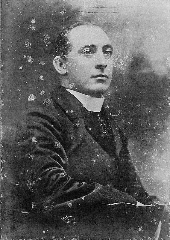 Man in sitting in chair dressed in priest clothing