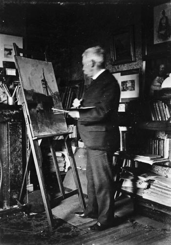 Photograph of William Hodgkins standing at an easel painting