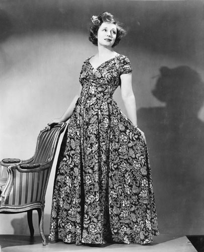 Nola Luxford wearing the first dress made from a fabric of her design, 1940s