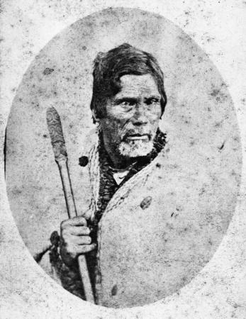A photograph showing Te Awa-i-taia holding a carved wooden staff