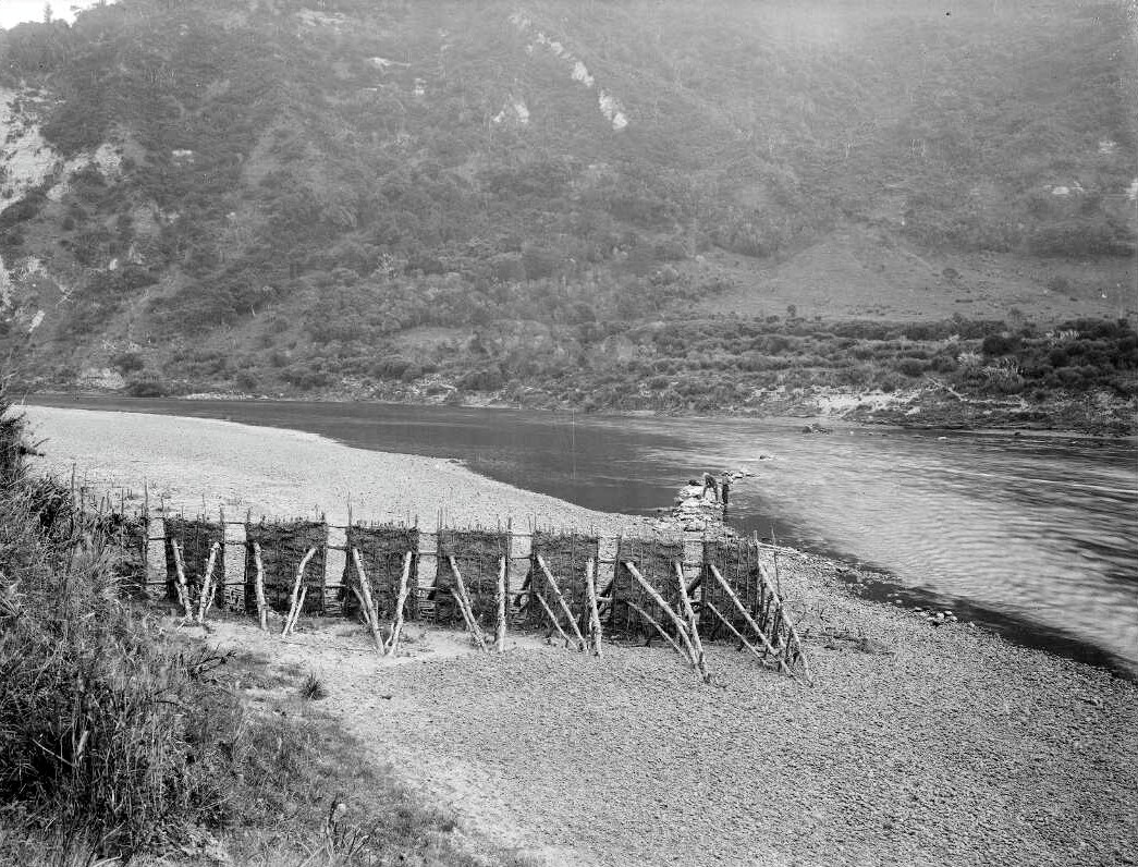 Temporary drying wall on side of river where people are standing