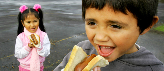 Children enjoy a sausage sizzle at Prospect School in Auckland, 2008