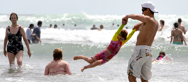 Holidaymakers frolic in the sea at Piha beach, Boxing Day 2009