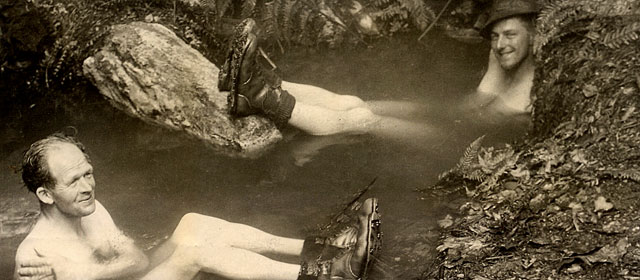 Two men soak in a natural thermal pool