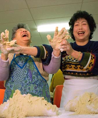 Ng Soon Yee (left) and Mel Jean Chin (right) making red bean dumplings for a Chinese bazaar, 1995