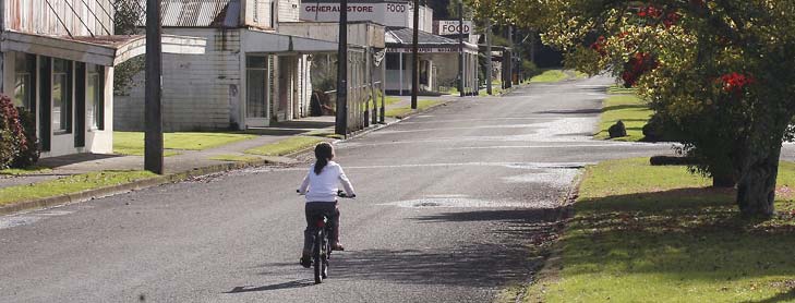 Child riding down empty street in town