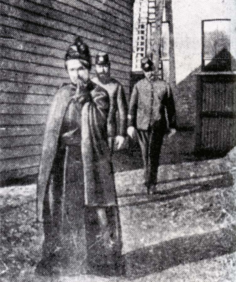 Woman holding hand to her mouth following by two policemen in uniform