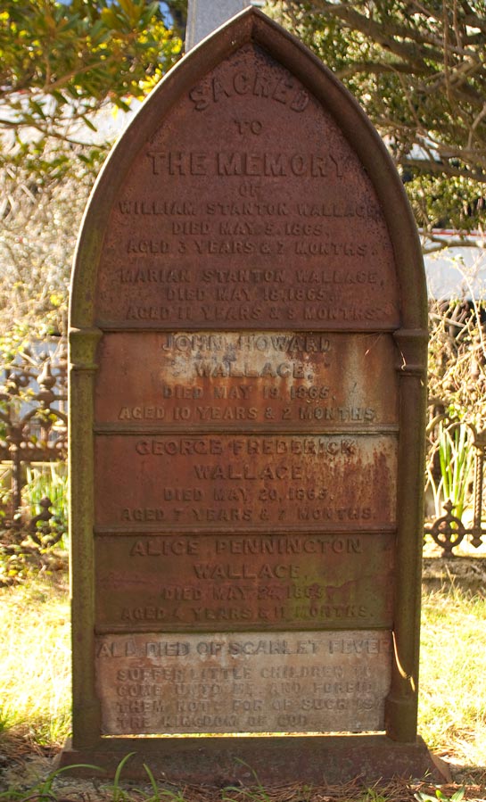 A gravestone in a cemetery listing the names of five children from the same family.