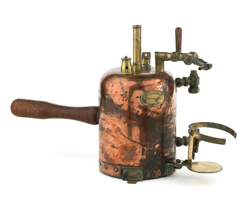 A copper and brass inhaler with a wooden handle.