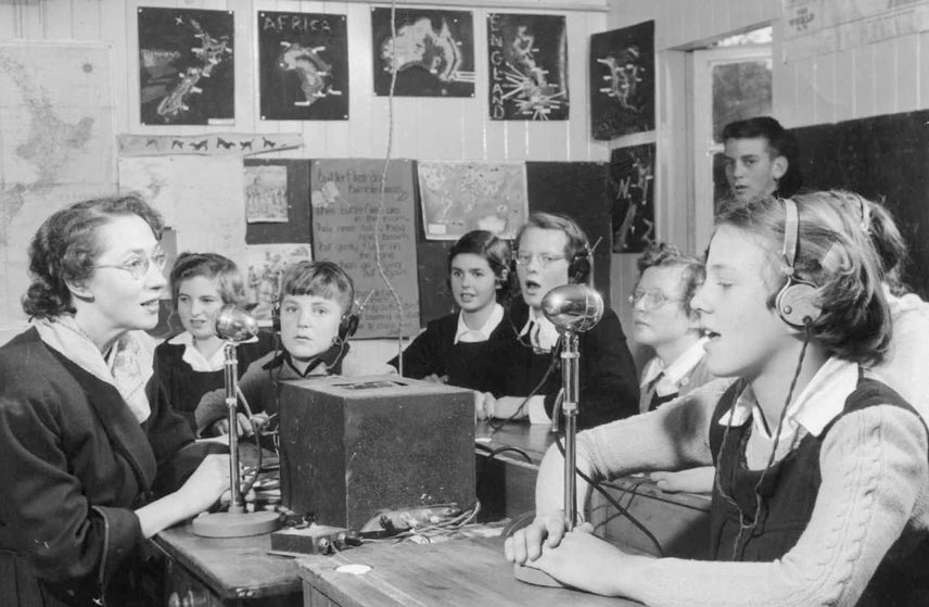 Children in class using microphones and headphones.