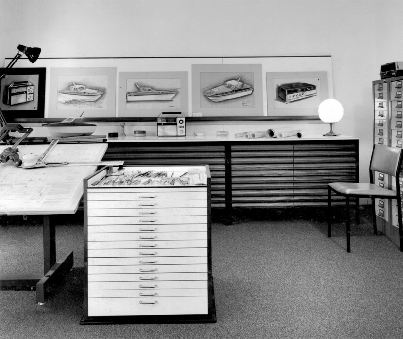 A photograph showing a room with a work desk, office furniture, sketches and models