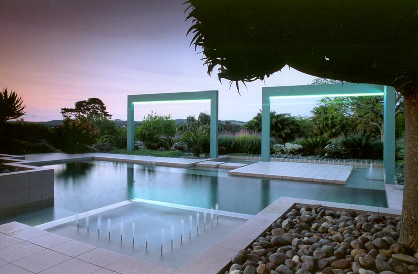 Photograph of a rectilinear pool surrounded by footpaths and plantings, with two rectangular frames in front of a view of plants and landscape