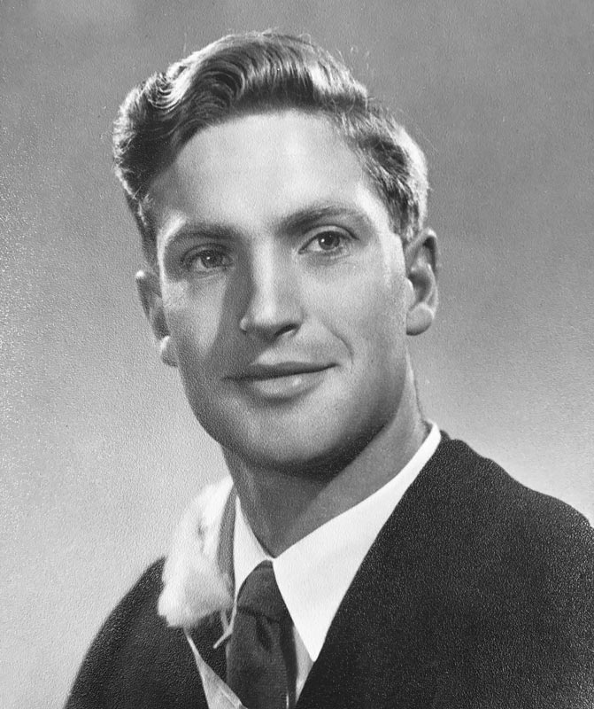 Head and shoulders portrait of Harry Turbott as young man, wearing a graduation gown. 