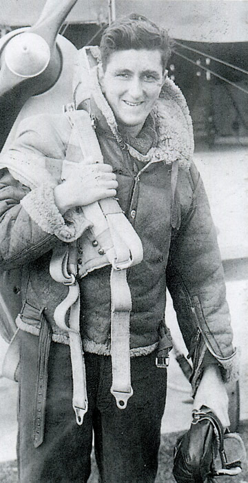 Les Hutchins as a young man, dressed in aviators’ clothing and standing in front of an aeroplane. 